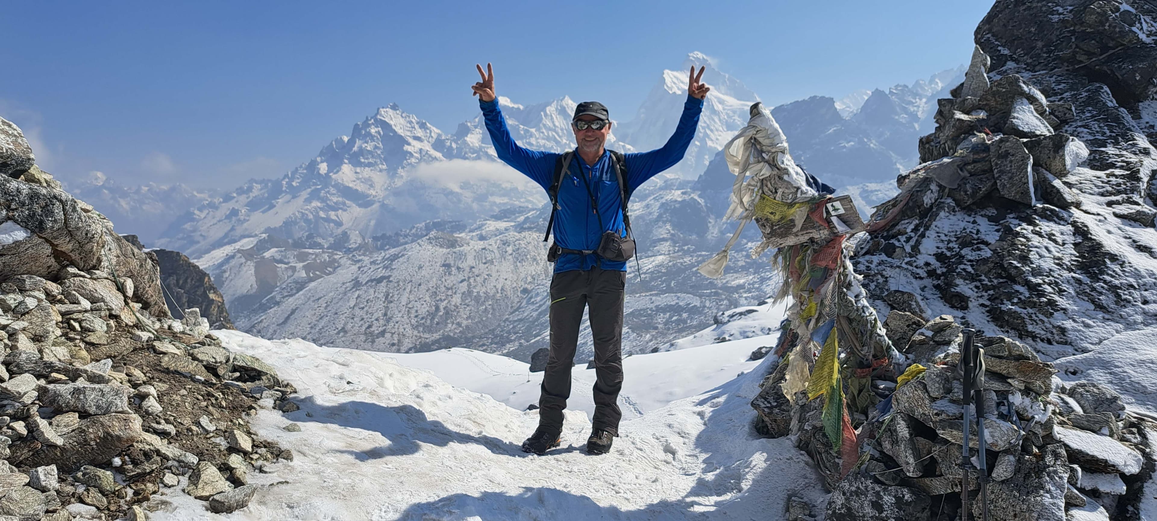 Trek 8586 Trekkers posing with two hands raised, discovering the natural wonders of the Kanchenjunga region