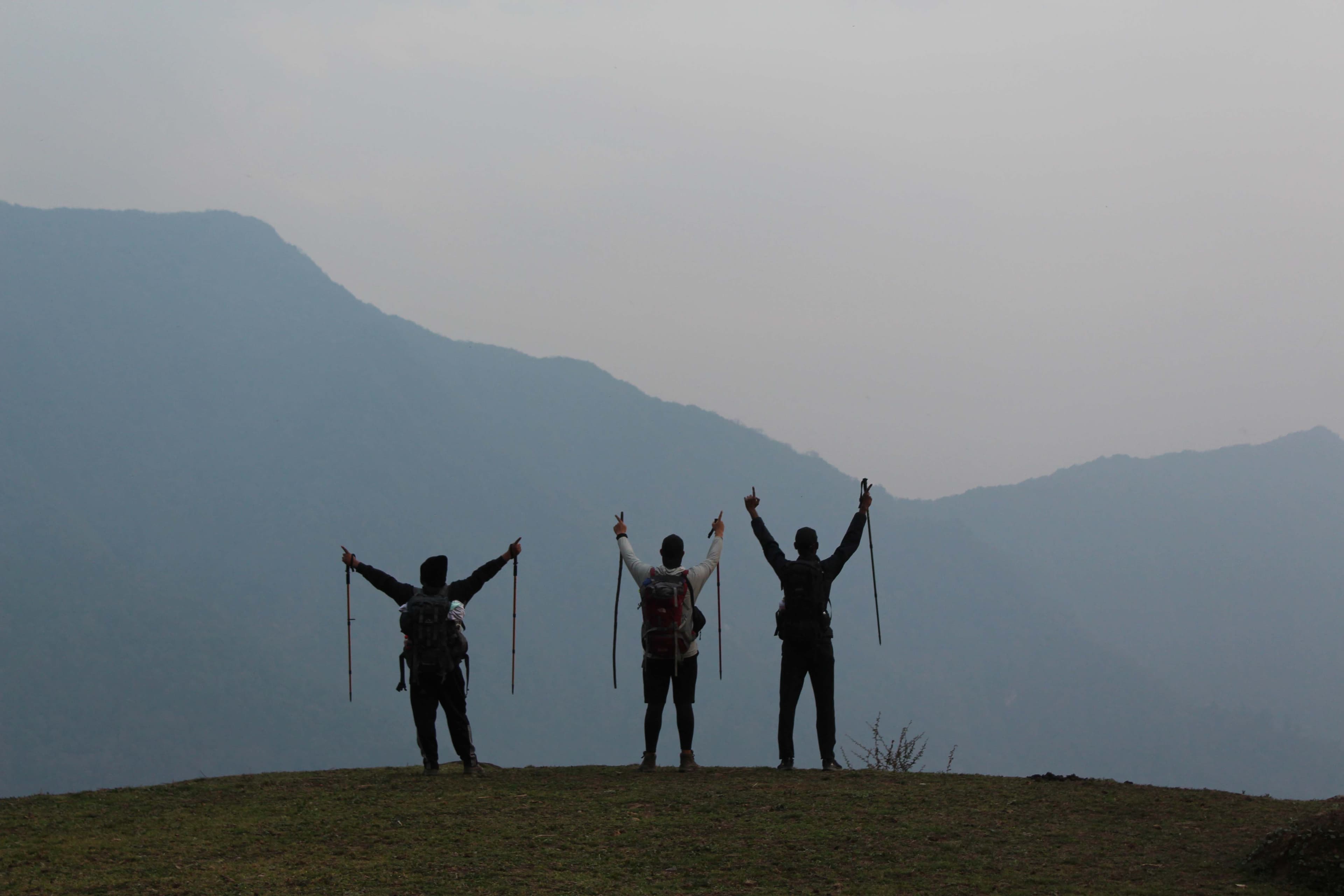 Trekkers waving with hands raised looking at landscape of Annapurna Circuit in Annapurna Region, Trek 8586 adventure journey