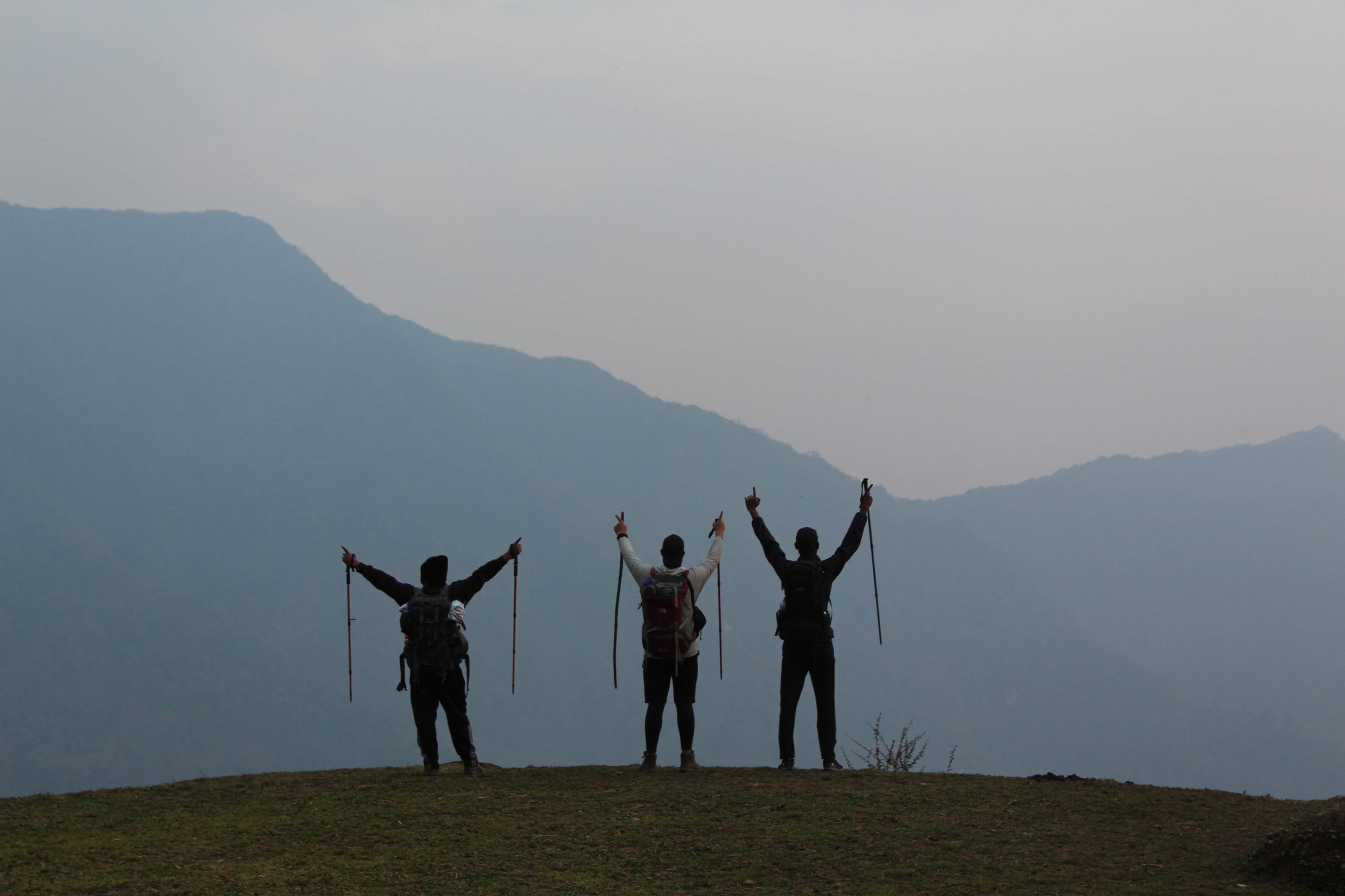 Trekkers waving with hands raised looking at landscape of Annapurna Circuit in Annapurna Region, Trek 8586 adventure journey